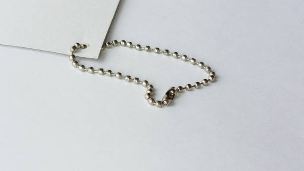 A metal, ball chain for tags, keychains on a white background close-up. Advertising background, space for text.
