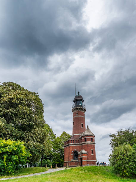 istock Historic Brick Lighthouse Amidst Lush Greenery and Overcast Skies, Kiel Germany 2183427439