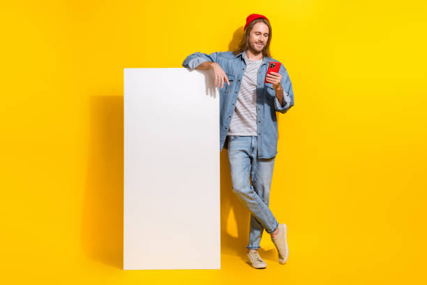 istock Full length photo of cheerful guy dressed shirt texting apple samsung gadget empty space isolated yellow color background 2183442848