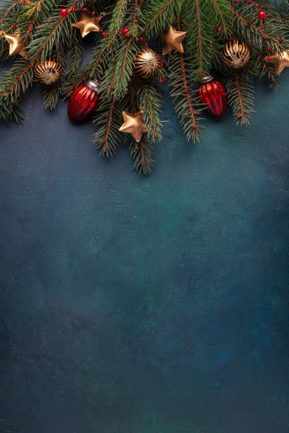 istock Fir branches with Christmas decorations on a  dark blue-green painted wooden background  with empty space for text.  Flat lay.  New Year and Christmas  background. 2183444273