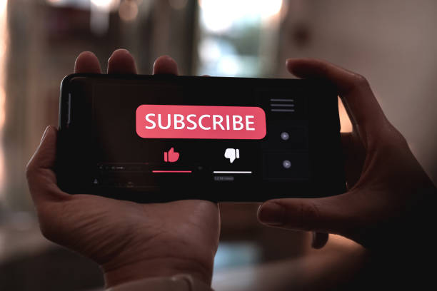 istock Woman using a smartphone to press red subscribe button on online media. Concepts of technology and following news, hot trends and new content on social media 2183447406