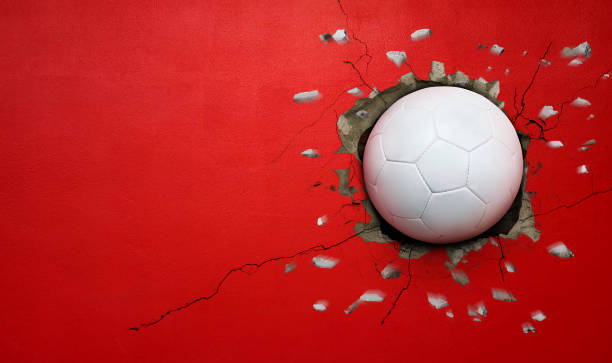 istock Soccer ball breaks through red concrete wall, concept of power, strength. 2183450073