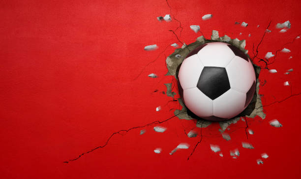 istock Soccer ball breaks through red concrete wall, concept of power, strength. 2183450075