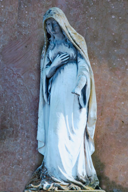 Virgin Mary ancient statue against stone background