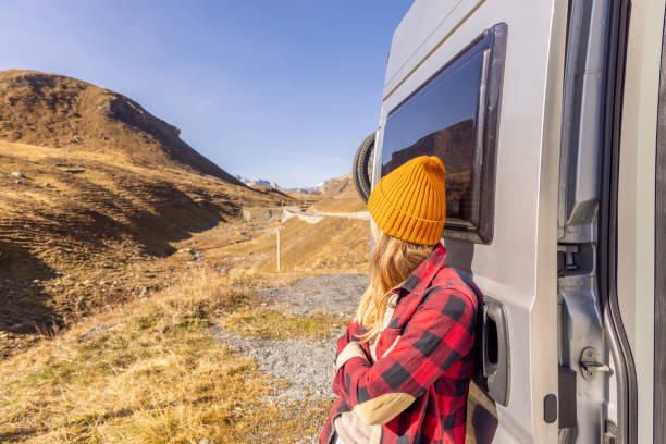 istock Woman Relaxing by Camper Van in Rugged Mountain Landscape 2183454687