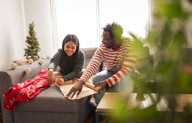 istock Happy couple packing Christmas presents at home 2183455677