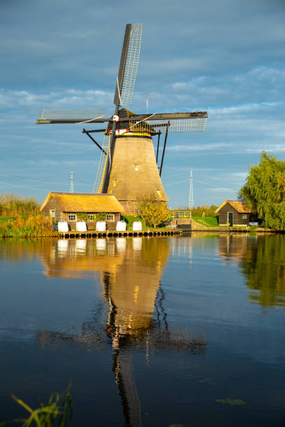 istock a windmill with a small house with reflection in the canal at kinderdijk in Netherlands, travel background image 2183455851