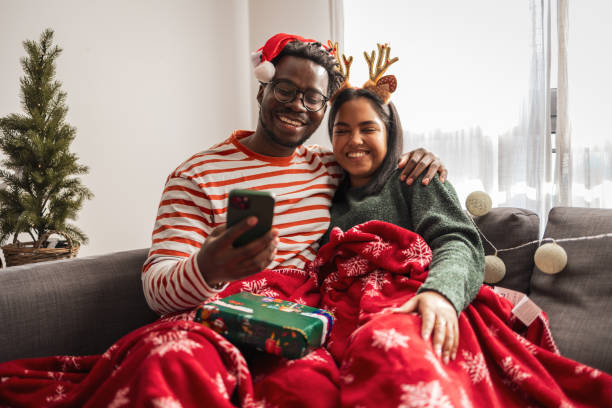 istock Young couple using mobile phone on the Christmas morning 2183456181