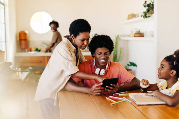 istock Mother and siblings engaged in educational activities at home 2183456435
