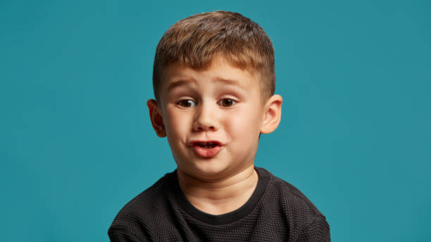 istock With wide eyes and shocked expression, boy seems surprised or curious against blue studio background, in mid-conversation, as if he telling funny story. 2183458783