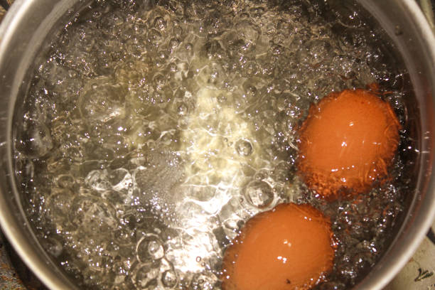 istock two brown chicken eggs are boiled in a saucepan 2183459452