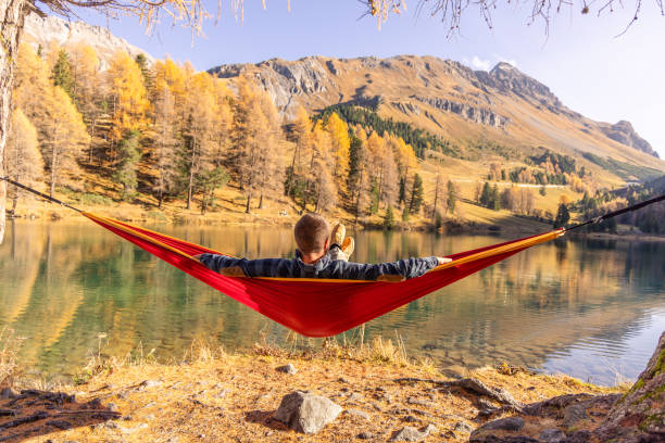 istock A man relaxing on an hammock by an alpine lake in Autumn 2183459630