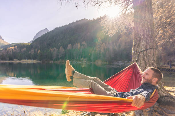 istock A man relaxing on an hammock by an alpine lake in Autumn 2183459675