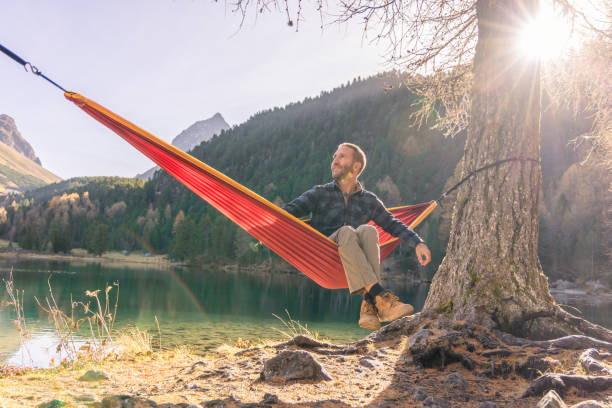 istock A man relaxing on an hammock by an alpine lake in Autumn 2183459714