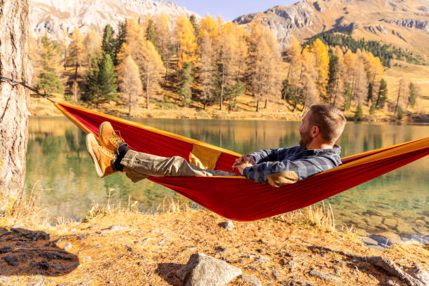 istock A man relaxing on an hammock by an alpine lake in Autumn 2183459743