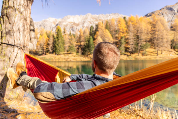 istock Man Relaxing in Hammock Overlooking Lake in Autumn Landscape 2183459768