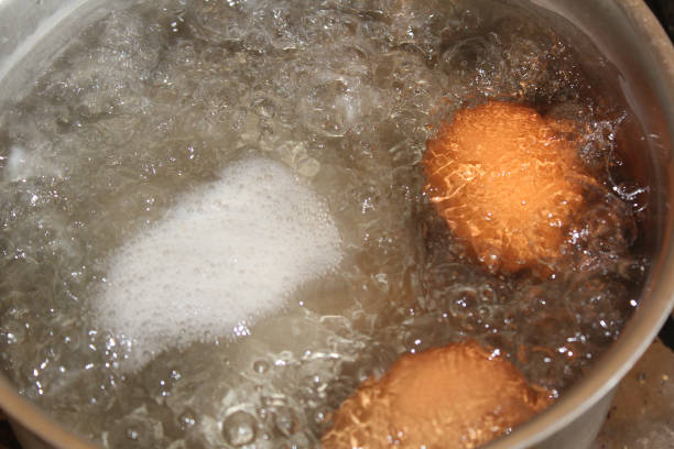 istock two brown chicken eggs are boiled in a saucepan in water with foam 2183460311