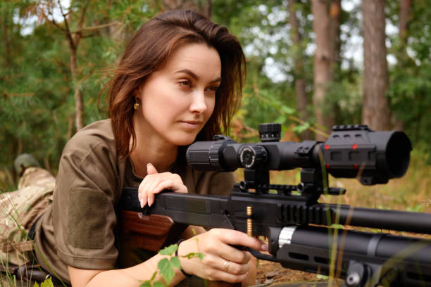 istock A skilled marksman prepares to take aim with a high-powered rifle in a natural forest setting during daylight hours, showcasing focus and precision in the wilderness 2183463505