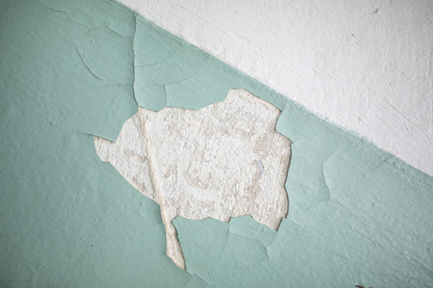 istock Cracked, peeling paint on the wall. A wall with old cracked blue paint. Patterns of cracks. 2183464632