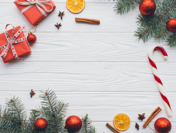 istock Christmas composition. Gifts, pine cones, fir branches, candy, spices and other decorations on wooden white background. Flat lay, top view. 2183466987