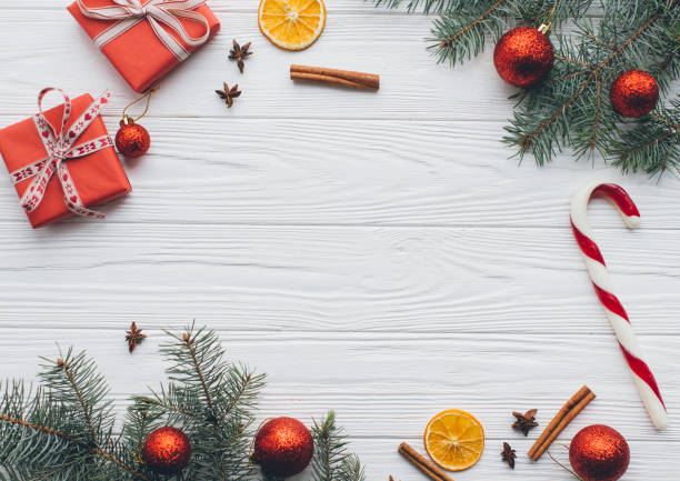 istock Christmas composition. Gifts, pine cones, fir branches, candy, spices and other decorations on wooden white background. Flat lay, top view. 2183466990