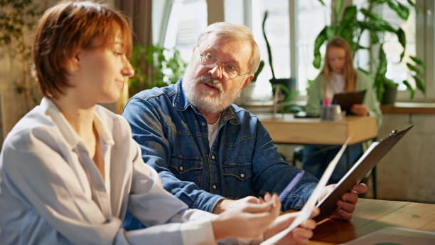 istock Experienced team leader explains charts and graphs, helping colleagues understand financial data and growth trends 2183470971
