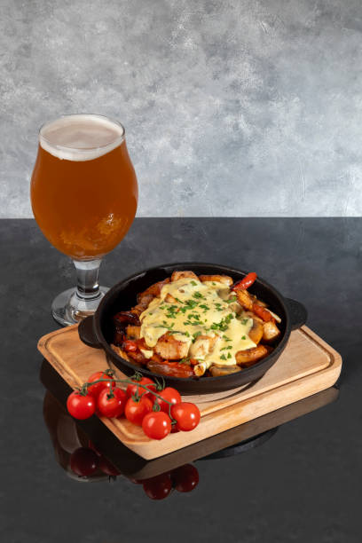 Stewed chicken, onions, potatoes and various vegetables in a cast iron skillet. Stewed chicken, onions, potatoes and various vegetables in a cast iron skillet. Menu concept, copy space braising pan stock pictures, royalty-free photos & images