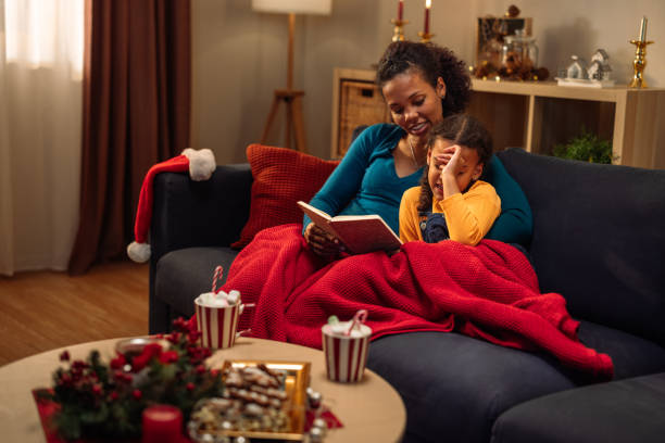 istock Mother and daughter reading a book on the sofa 2183474976