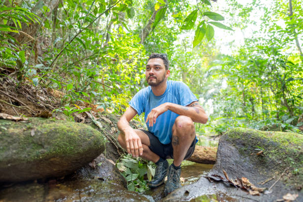 istock Young man washes his face in the clear waters of the forest. 2183478430