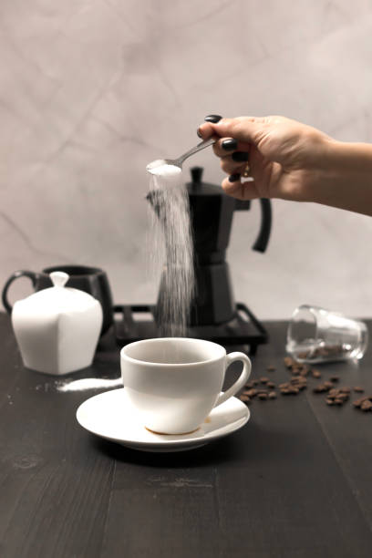 istock Black coffee is poured into a cup, on a black background. pour milk into coffee 2183488704
