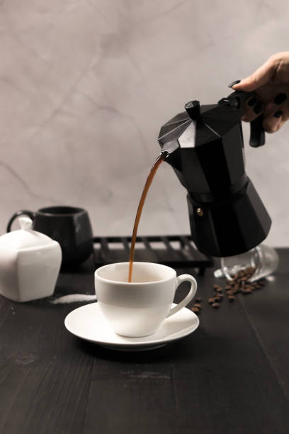 istock Black coffee is poured into a cup, on a black background. pour milk into coffee 2183488713