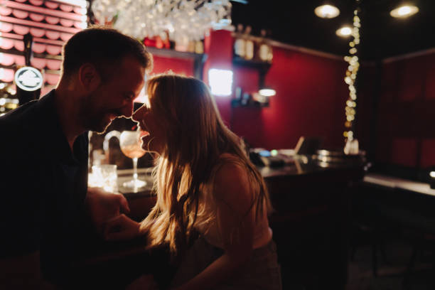 istock Couple enjoying drinks and laughter at a bar 2183491375