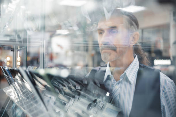istock Man looking through glass display in store 2183494153