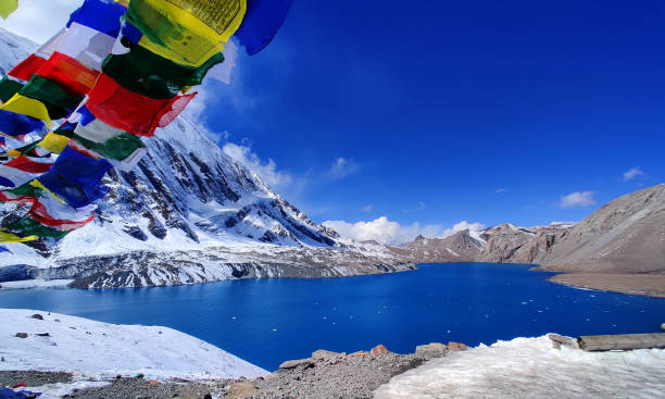 istock The breathtaking Tilicho Lake, framed by colourful prayer flags, sits peacefully amidst the snow-covered peaks of the Annapurna range. 2183496314