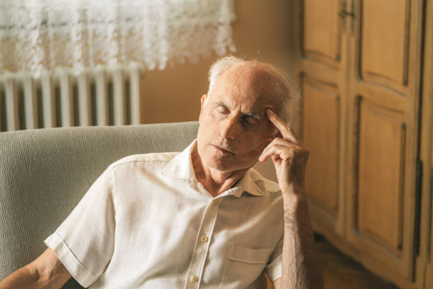 Senior man taking medicine and vitamins after measuring his blood pressure at home. Rheumatic disease, pain killers.