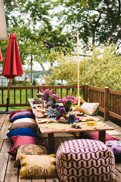 istock Bohemian outdoor table setting with pillows, flowers, and lights. 2183497109