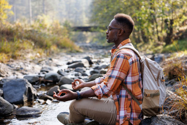 istock Man meditating in yoga pose by a forest river 2183498564
