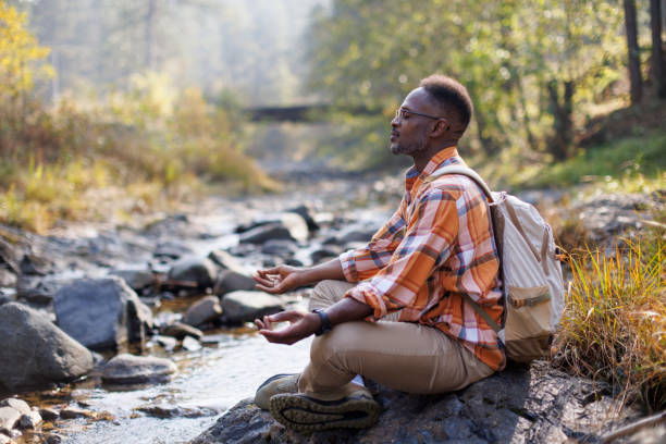 istock Man meditating in yoga pose by a forest river 2183498775
