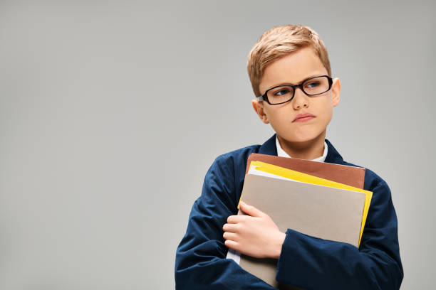Child little boy with red glasses reading a red book