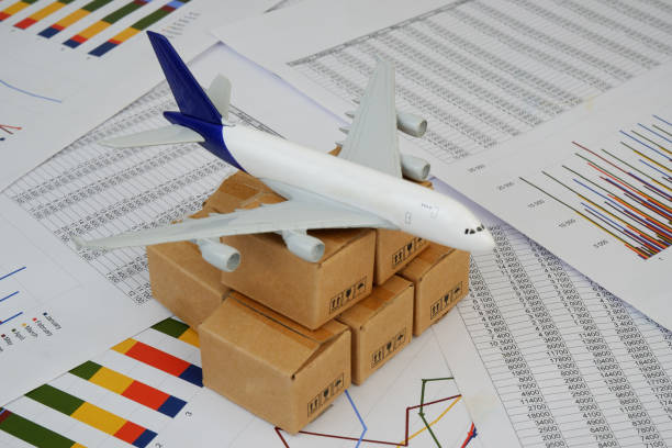 istock Airplane model and shipping carton boxes on financial documents close up. 2183499860