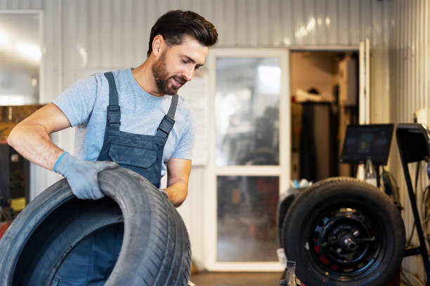 istock Mechanic holding a tire in a workshop during seasonal change 2183500348
