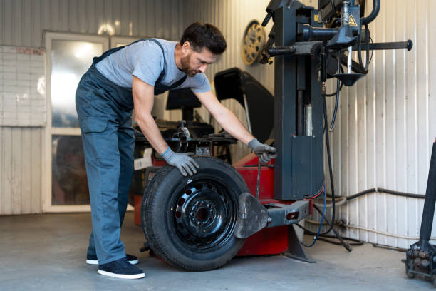 istock Mechanic mounting a tire on a tire changer machine in a workshop 2183500438