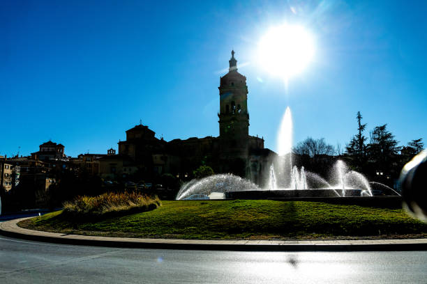 Historic building with fountain and tower in sunlight; Guadix architecture.