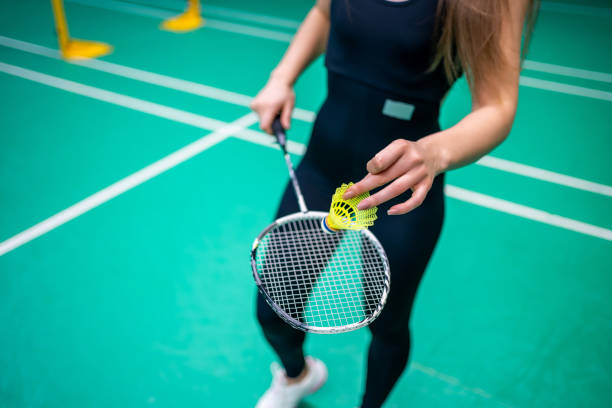 istock Sports young woman with racket and shuttlecock is practicing serve before playing in badminton on inside court 2183500700