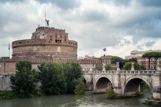 Rome, Italy - September 8, 2022: Heavy clouds above medieval St. Angelo castle and the bridge over Tiber river in Rome, Italy.
