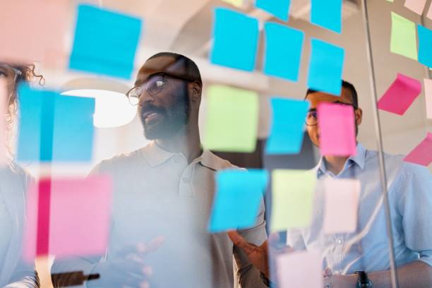 istock Man presenting his ideas on a glass wall during a business meeting 2183505232