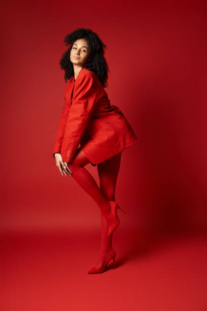 istock Vibrant young woman in striking red ensemble poses confidently against bold backdrop 2183509555