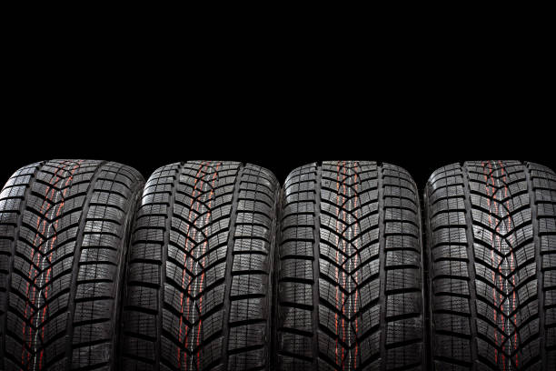 istock Four winter tires standing on black background 2183511945