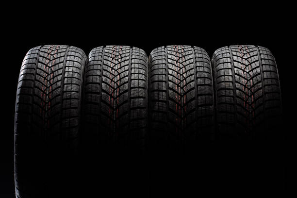istock Four winter tires standing on black background 2183511952