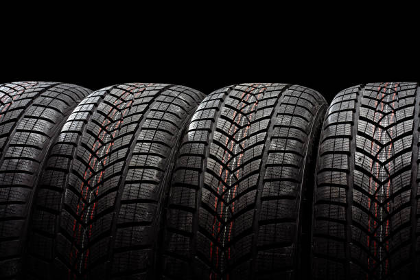 istock Four winter tires standing on black background 2183511968